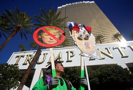 A protestor holds signs at the Wall of Tacos demonstration in front of the Trump International Hotel Las Vegas before the last 2016 U.S. presidential debate in Las Vegas, Nevada, U.S., October 19, 2016. REUTERS/Jim Urquhart