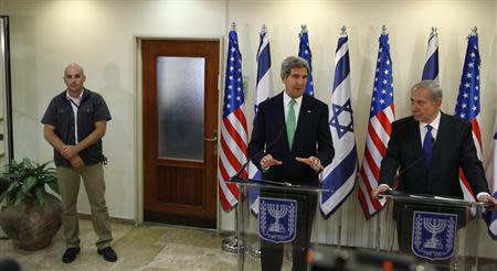 An Israeli security member stands guard as U.S. Secretary of State John Kerry (C) speaks to the media next to Israel's Prime Minister Benjamin Netanyahu (R) at the prime minister's office in Jerusalem September 15, 2013. REUTERS/Larry Downing