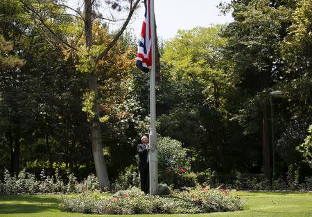 Gary Thompson, overseas security manager at Britain's Foreign and Commonwealth Office, raises the Union flag at British Embassy in Tehran, Iran, August 23, 2015. REUTERS/Darren Staples