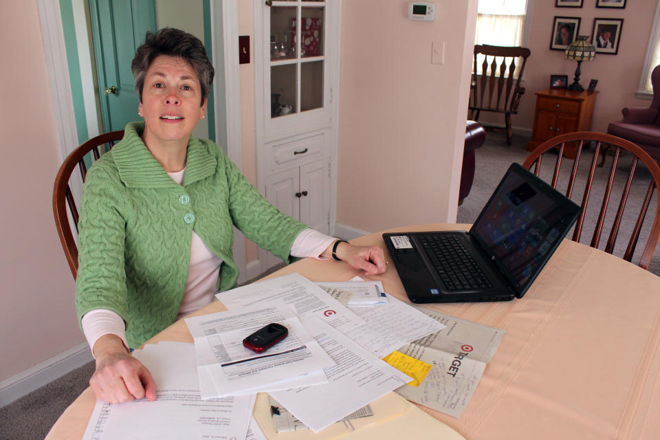 In this April 10, 2014 photo Laura Hankins sits with the paperwork in West Milwaukee that she needed to go through to help her 19-year-old daughter with her federal returns after finding out that someone using her name had already filed for a refund. It took Laura about 20 hours to fill out forms, gather information and photocopy documents because her daughter, Claire Hankins, couldn’t file electronically after the tax identity theft was discovered. (AP Photo/Carrie Antlfinger)