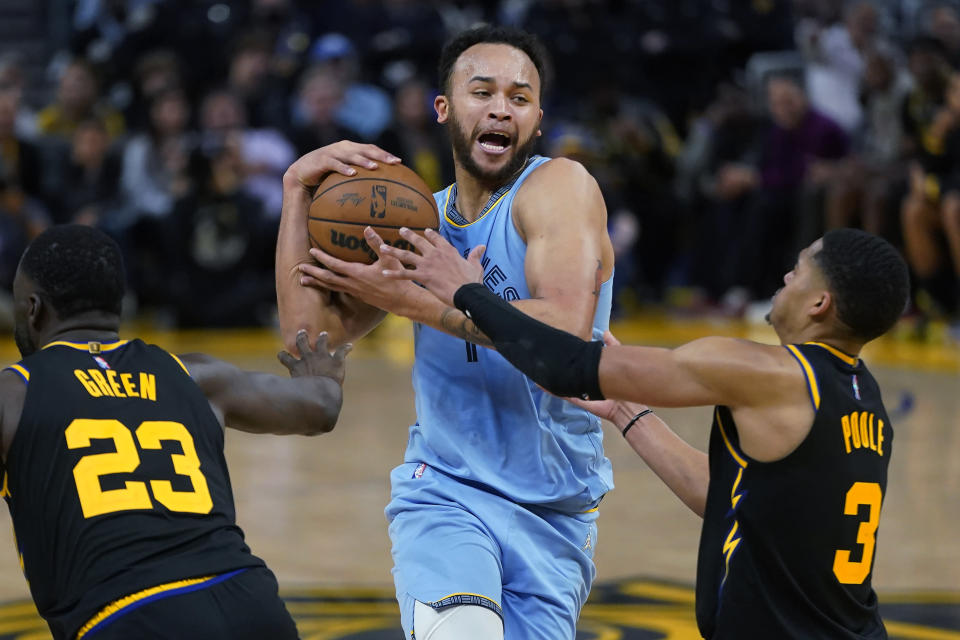 Memphis Grizzlies forward Kyle Anderson, middle, is called for an offensive foul as he drives on Golden State Warriors guard Jordan Poole (3) during the second half of Game 3 of an NBA basketball Western Conference playoff semifinal in San Francisco, Saturday, May 7, 2022. (AP Photo/Jeff Chiu)