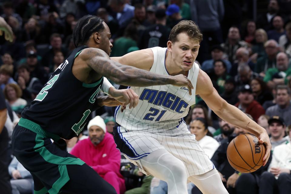 Orlando Magic's Moritz Wagner (21) drives past Boston Celtics' Oshae Brissett (12) during the second half of an NBA basketball game Friday, Dec. 15, 2023, in Boston. (AP Photo/Michael Dwyer)