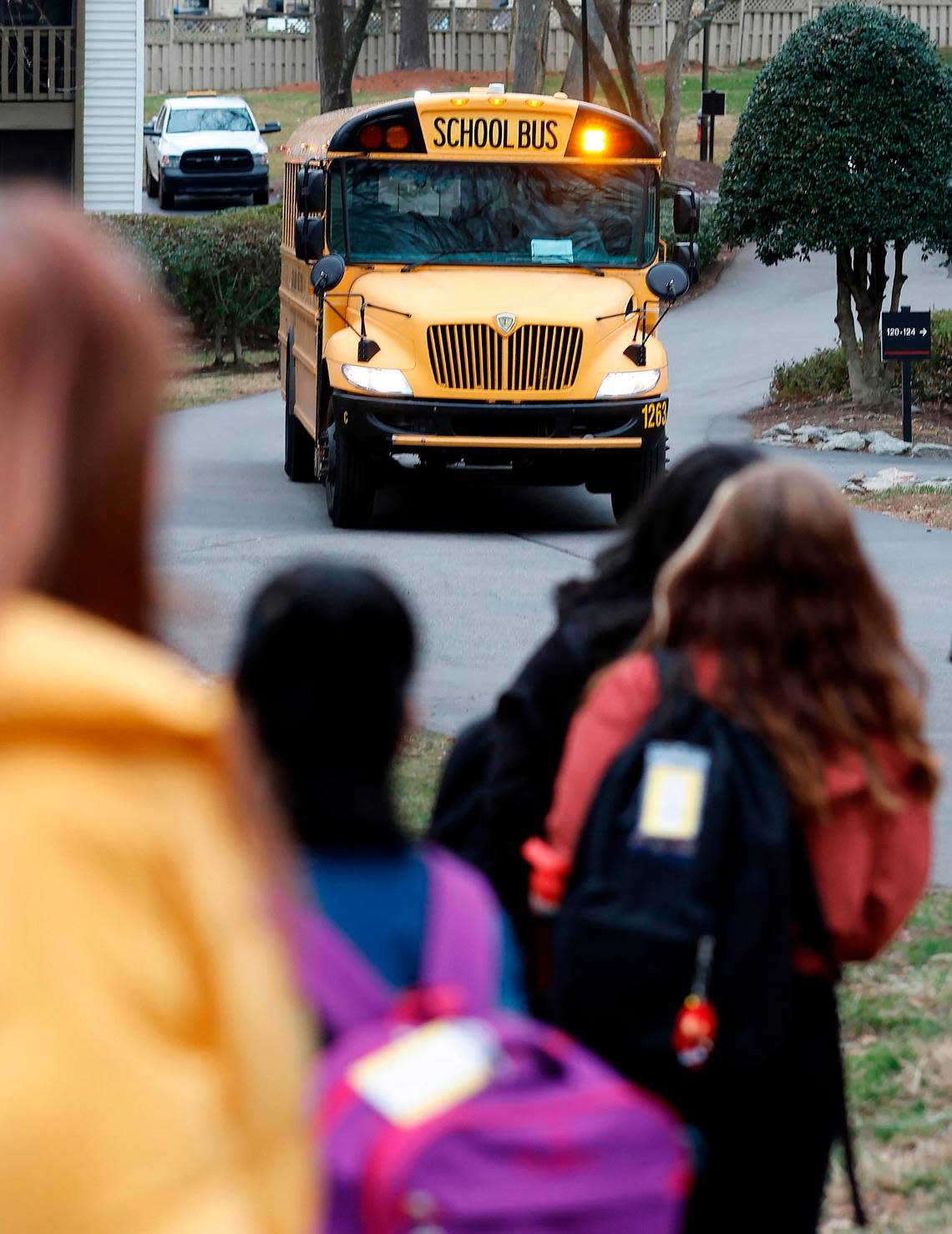 Students wait to board an approaching Wake County Schools bus earlier this year. Due to a driver shortage, Wake County will switch to an A/B schedule on 17 routes where middle school and high school students won’t get daily bus service.