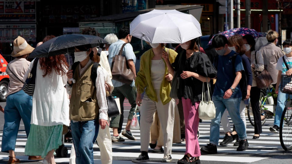 日本東京的夏天，人們在烈日下走過人行道。美聯社