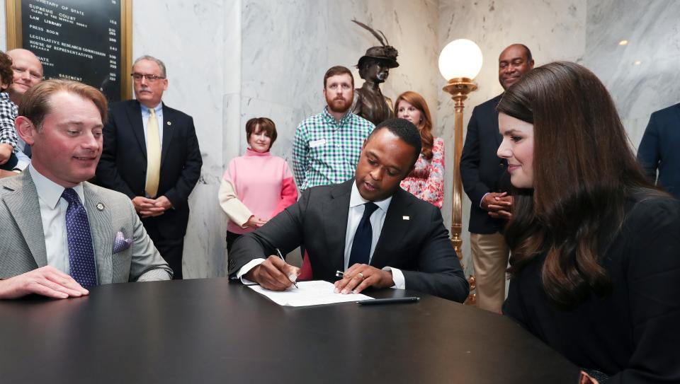 Kentucky Attorney General Daniel Cameron, center, signed papers to officially enter the race for governor as his wife Makenze Cameron, right, and Secretary of State Michael Adams look on at the State Capitol Building in Frankfort, Ky. on Jan. 3, 2023.  