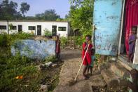 Jonelson Princeton, 7, left, who survived cholera as a newborn, stands near his sister Ritchina Princeton, center, and other siblings where they live with their parents and grandmother in what was once an office on the former U.N. base in Mirebalais, Haiti, Monday, Oct. 19, 2020. Ten years after a cholera epidemic swept through Haiti and killed thousands, families of victims still struggle financially and await compensation from the United Nations as many continue to drink from and bathe in a river that became ground zero for the waterborne disease. (AP Photo/Dieu Nalio Chery)