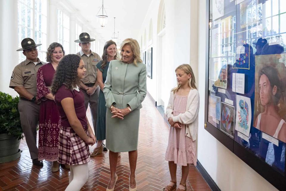 <p>Official White House Photographer Erin Scott</p> First lady Jill Biden shows Paris Robinson, age 10, and Autum Cobb, age 8, a display of their artwork in the Military Children Children