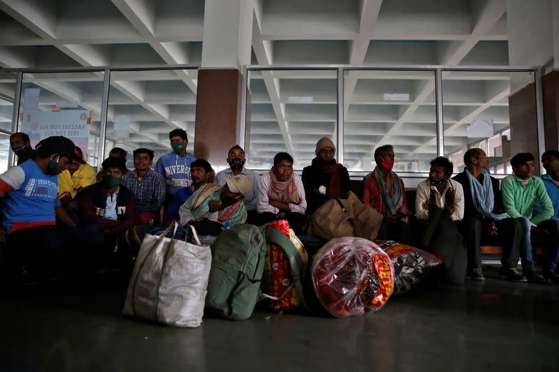 Indian migrant workers wait inside a railway station to board trains to their home states, on outskirts of Srinagar