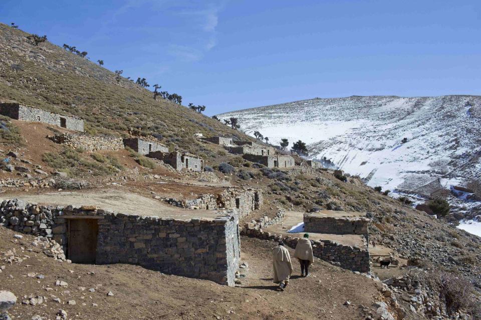 Varios hombres bereberes caminan por el valle rumbo a sus casas.