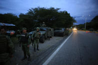 Soldiers wearing the armbands of Mexico's National Guard man a migration checkpoint north of Comitan, Chiapas State, Mexico, Saturday, June 15, 2019. Under pressure from the U.S. to slow the flow of migrants north, Mexico plans to deploy thousands of National Guard troops by Tuesday to its southern border region.(AP Photo/Rebecca Blackwell)