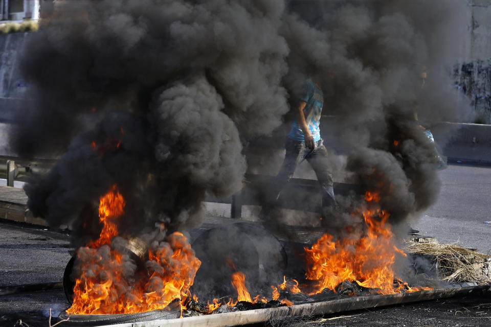 Anti-government protesters burn tires to close the main highways during ongoing protests against the government, in Khaldeh, south of Beirut, Lebanon, Thursday, Nov. 14, 2019. Protesters have been holding demonstrations since Oct. 17 demanding an end to widespread corruption and mismanagement by the political class that has ruled the country for three decades. (AP Photo/Bilal Hussein)