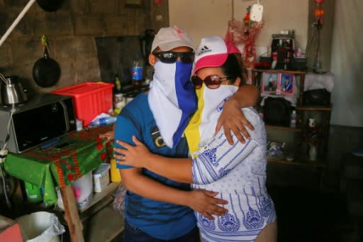 Opposition prisoner Jonathan Lacayo (L), embraces his mother at his house in Managua on June 10, 2019, both wearing masks for fear of reprisal attacks by supporters of President Daniel Ortega