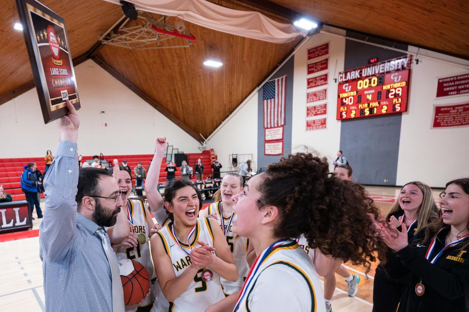 Tantasqua girls' basketball coach Andy Haley raises the championship plaque after the Warriors topped Northbridge, 40-29, to win the Clark Tournament Large School title.