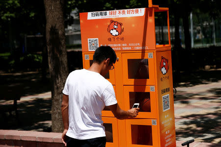 A man uses a court-side basketball vending machine at the Beijing Language and Culture University in Beijing, China, May 24, 2017. Picture taken May 24, 2017. REUTERS/Thomas Peter