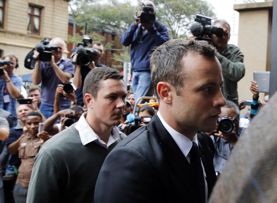 Olympic and Paralympic track star Oscar Pistorius (R) arrives at court ahead of the fourth day of his trial for the murder of his girlfriend Reeva Steenkamp at the North Gauteng High Court in Pretoria, March 6, 2014. REUTERS/Mike Hutchings (SOUTH AFRICA - Tags: SPORT ATHLETICS CRIME LAW)