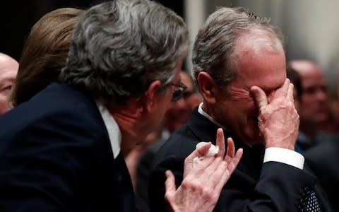 Former President George W Bush cries after speaking during the state funeral for his father - Credit: Getty