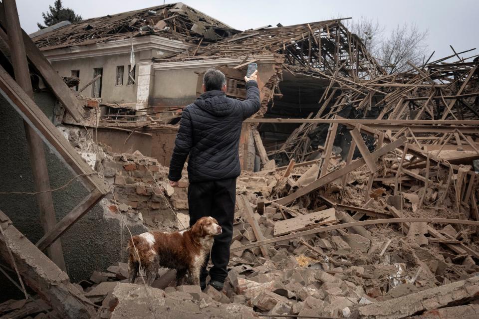A local resident looks at the of an industrial building surrounded by apartment houses after a night Russian rocket attack in Sloviansk, Ukraine, in late January. Timothy Hoyt of the Naval War College will discuss the war March 22 in an appearance for the Coudert Institute at the Sailfish Club.