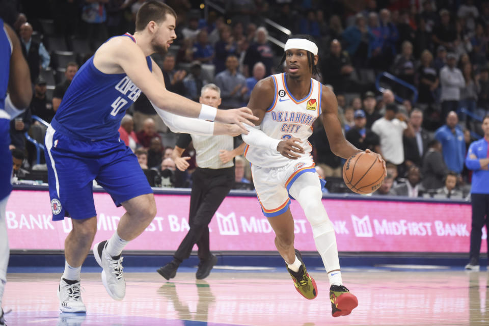 Oklahoma City Thunder guard Shai Gilgeous-Alexander, right, pushes past Los Angeles Clippers center Ivica Zubac, left, in the first half of an NBA basketball game, Thursday, Oct. 27, 2022, in Oklahoma City. (AP Photo/Kyle Phillips)