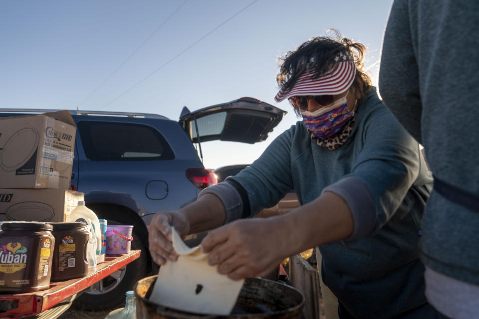 Karlene Goodluck places dough in oil to make Navajo fry bread outside of the Churchrock Chapter House in Church Rock, N.M., on Election Day, Tuesday, Nov. 8, 2022. (AP Photo/William C. Weaver IV)