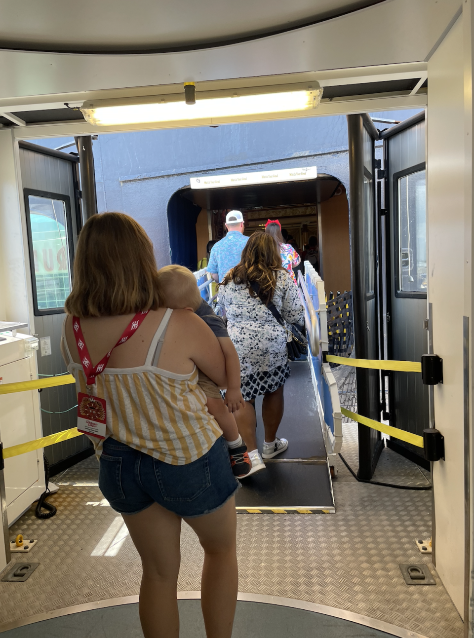 People boarding an airplane, one carrying a child