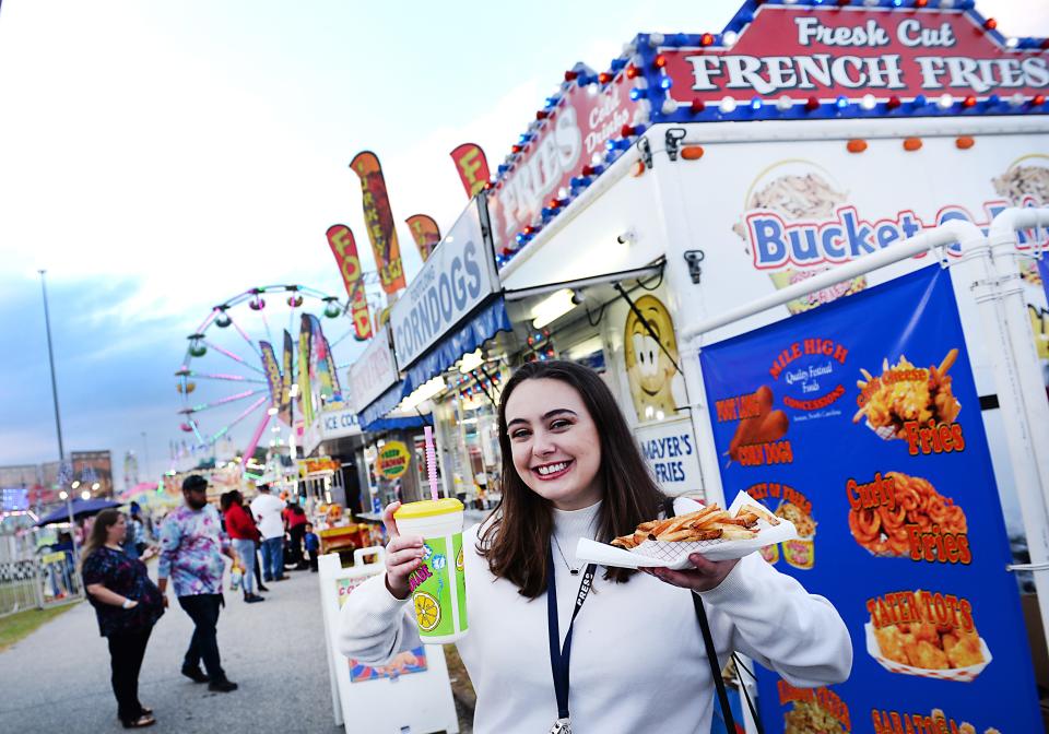 The Piedmont Interstate Fair gates will be open in Spartanburg  October 11-16. Joanna Johnson, Spartanburg Herald-Journal education and community reporter, takes on the fair. Here, she digs into Fresh cut French Fries and a drink.