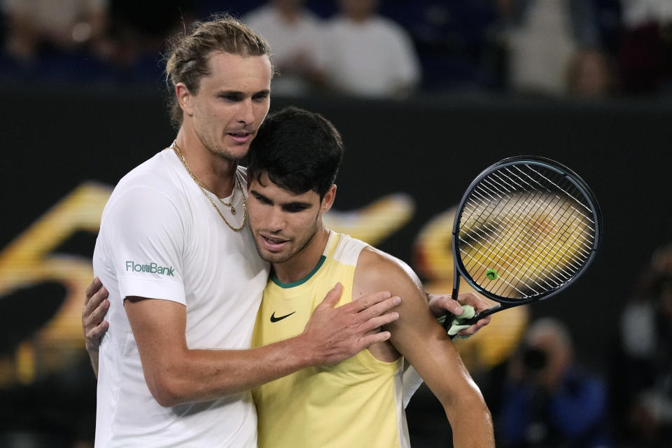 Alexander Zverev, left, of Germany is congratulated by Carlos Alcaraz of Spain following their quarterfinal match at the Australian Open tennis championships at Melbourne Park, Melbourne, Australia, early Thursday, Jan. 25, 2024. (AP Photo/Alessandra Tarantino)