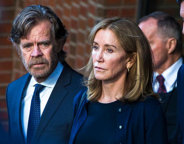Felicity Huffman (right) and her husband, William H. Macy, walk out of the courthouse in Boston on Sep. 13, 2019. Huffman was sentenced to 14 days in prison and community service for her role in the college admissions scandal. 