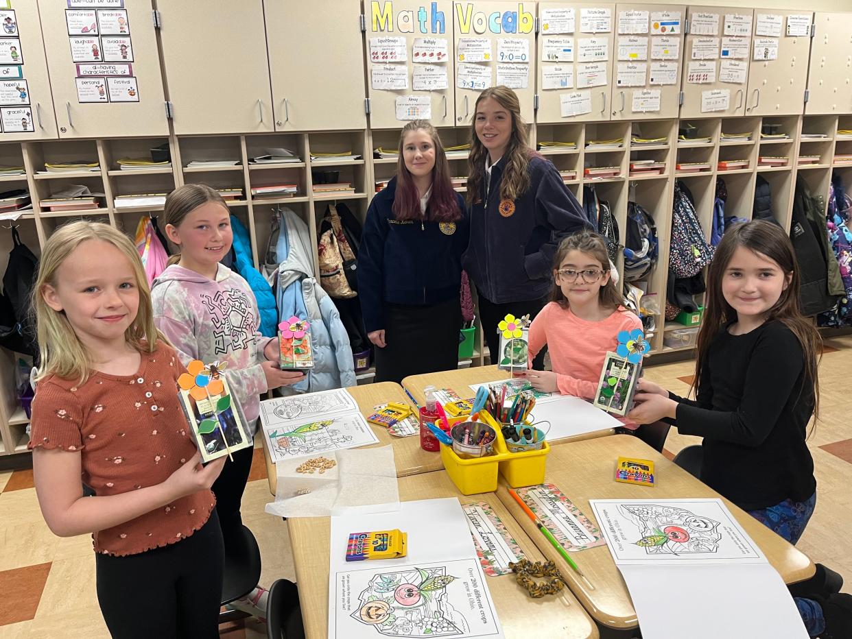 Clyde High School FFA members taught a unit on plant life cycles to all of the third graders in the school district and then completed a fun craft.  Students explained how seeds are used for food and fuel.  Children hold the the flower crafts they made.