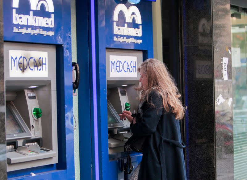 A woman uses an automated teller machine (ATM) of Bankmed in Beirut