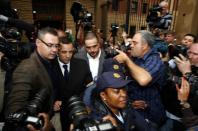 Members of the media photograph Olympic and Paralympic track star Oscar Pistorius (2nd L) as he leaves after his trial at the North Gauteng High Court in Pretoria March 4, 2014. Pistorius is on trial for murdering his girlfriend Reeva Steenkamp at his suburban Pretoria home on Valentine's Day last year. He says he mistook her for an intruder. REUTERS/Siphiwe Sibeko (SOUTH AFRICA - Tags: SPORT ATHLETICS CRIME LAW)