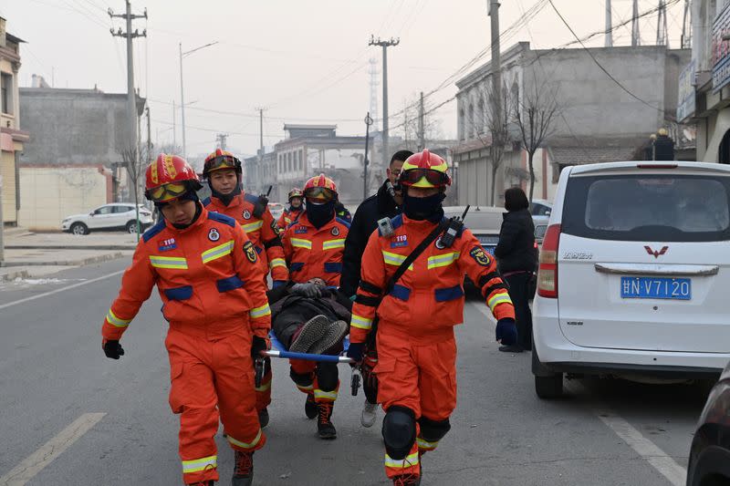Rescatistas transportan a un herido en una camilla en la ciudad de Dahejia tras el terremoto en el condado de Jishishan, provincia de Gansu, China