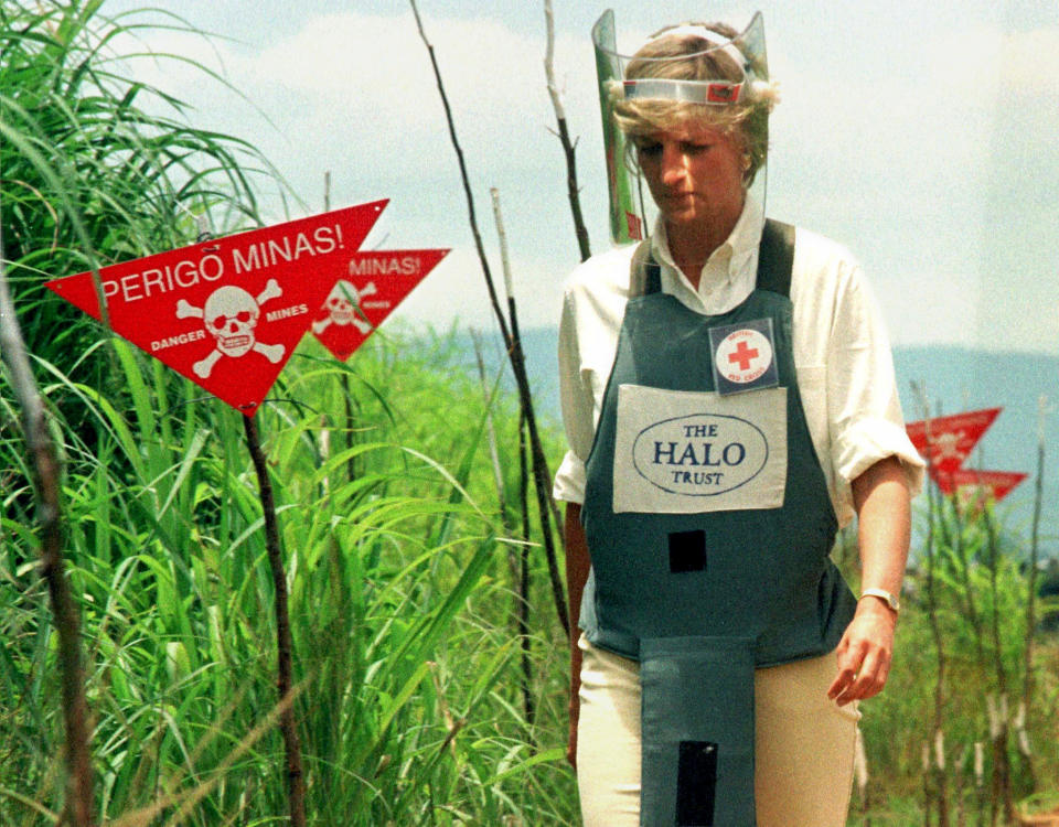 Diana Princess of Wales walks through a safety corridor in a land mine field in Huambo January 15. Diana is on a four day visit to Angola at the invitation of the British Red Cross to help increase awarness of the landmines problem world wide. The signs say 