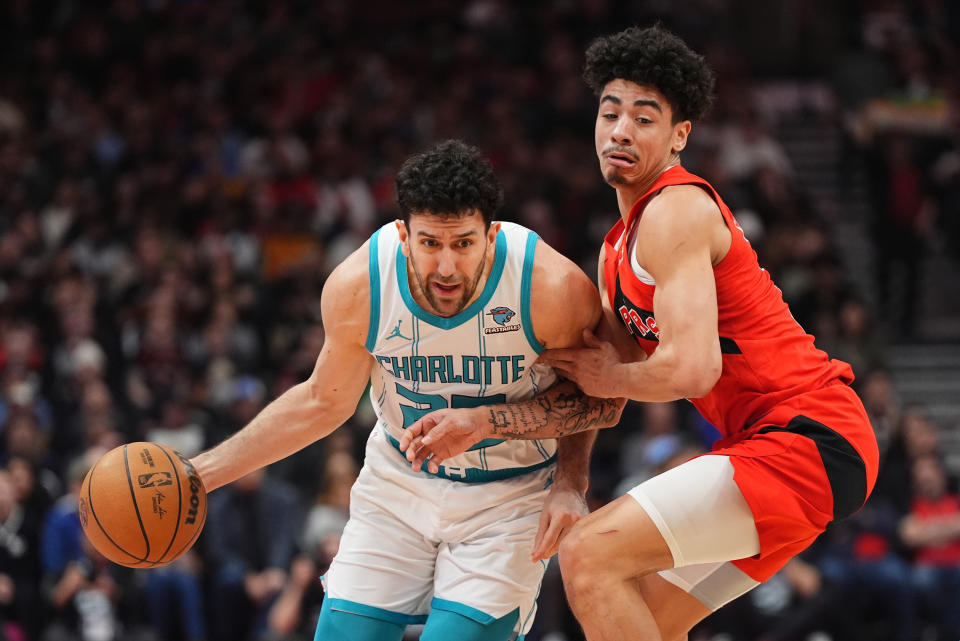 Charlotte Hornets' Vasilije Micić , left, tries to move around Toronto Raptors guard D.J. Carton, right, during first-half NBA basketball game action in Toronto, Sunday, March 3, 2024. (Frank Gunn/The Canadian Press via AP)