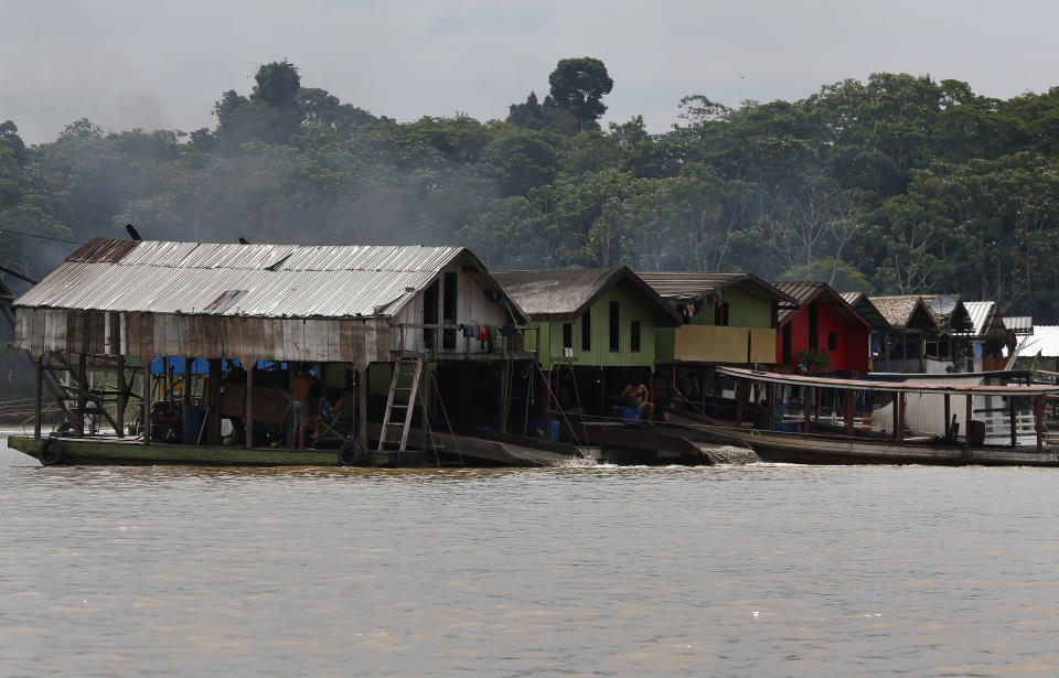 Dredging barges operated by illegal miners converge on the Madeira river, a tributary of the Amazon river, searching for gold, in Autazes, Amazonas state, Brazil, Thursday, Nov.25, 2021. Hundreds of mining barges have arrived during the past two weeks after rumors of gold spread, with environmentalists sounding the alarm about the unprecedented convergence of boats in the sensitive ecosystem. (AP Photo/Edmar Barros)