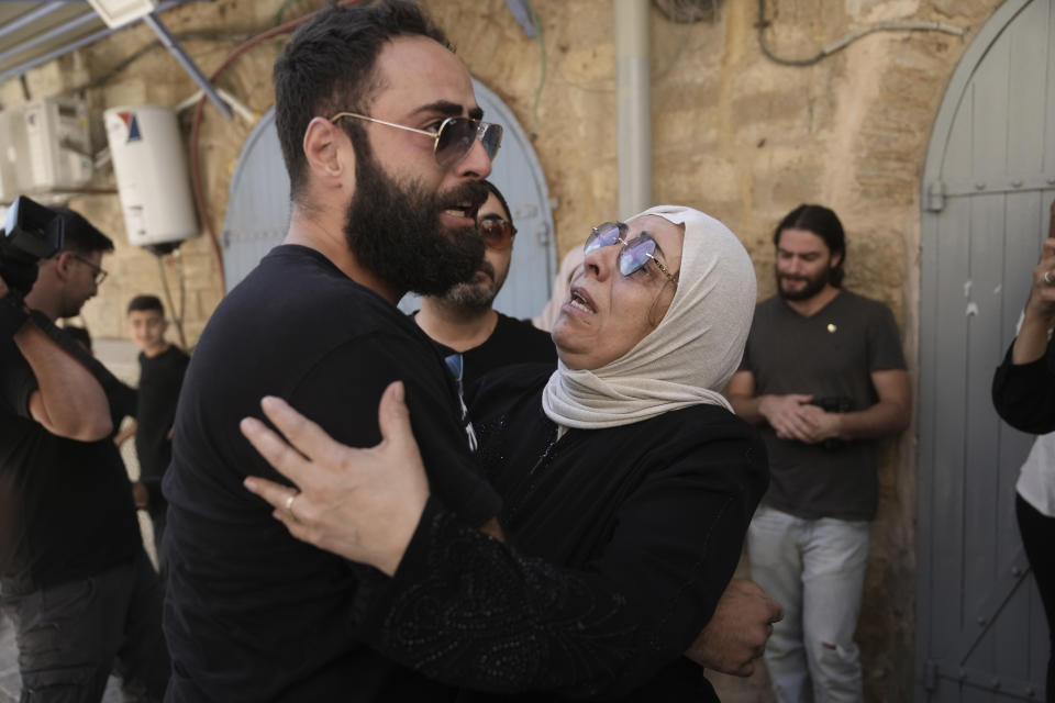 Nora Ghaith-Sub Laban, center, is comforted by her son after her family's eviction from their home to make way for Israeli settlers in Jerusalem's Old City, Tuesday, July 11, 2023. As the last remaining Palestinians in a building filled with settlers, the Ghaith-Sub Labans have battled Israeli attempts to evict them from their Old City home for over 45 years. Settlers claim the family are squatters who had been living in an apartment formerly owned by Jews. (AP Photo/Mahmoud Illean)