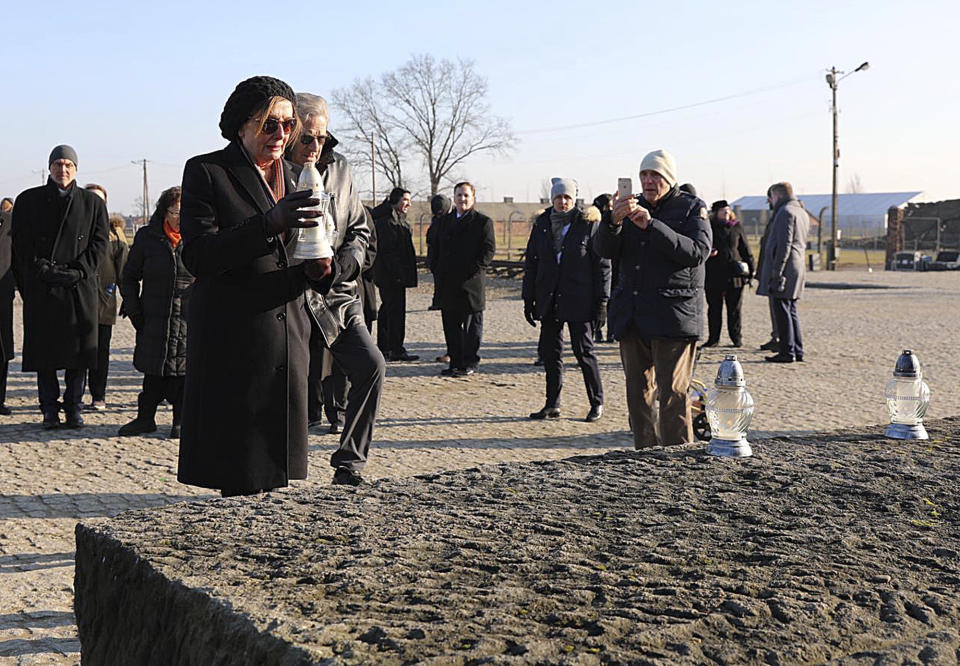 In this image provided by the US Consulate General in Krakow, U.S. House Speaker Nancy Pelosi places a memorial light on the monument to some 1.1 million victims of the World War II Nazi death camp of Auschwitz-Birkenau during a visit to the site of the former camp just days before the 75th anniversary of its 1945 liberation by the Soviet troops, at the Auschwitz-Birkenau Museum, in southern Poland, on Tuesday, Jan. 21, 2020. (US Consulate General in Krakow via AP)