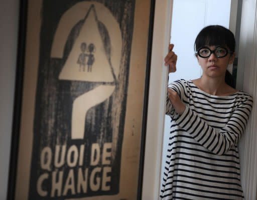 Political activist Ger Choi Tze-kwan stands next to a poster reading "Quoi De Change?" or "What has changed" from the May 1968 student protests in Paris on May 12 in Hong Kong. A plan to toughen Hong Kong's copyright law has sparked protests from artists, who say it will stifle free speech, criminalise satire and threaten the city's growing status as a major arts hub