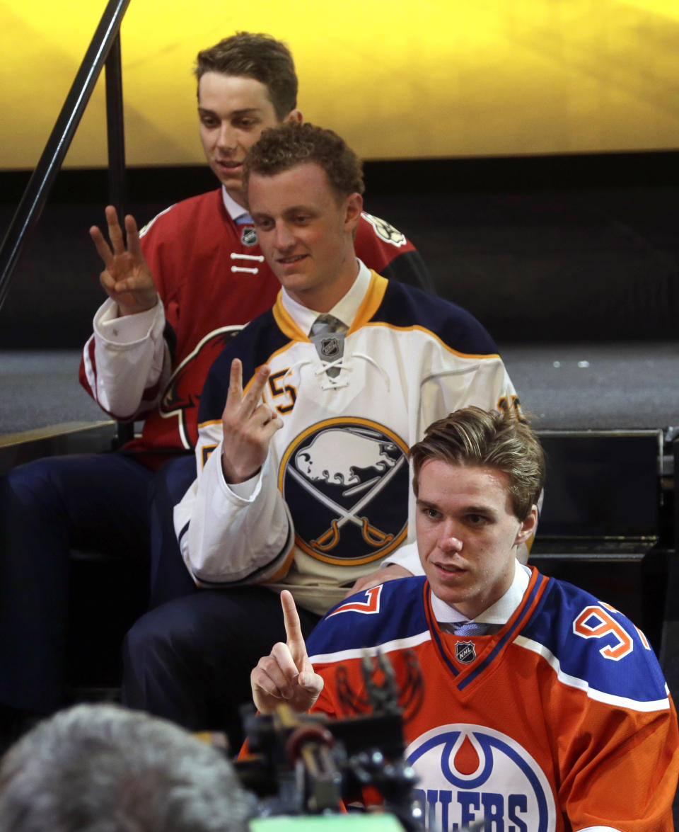 FILE - Connor McDavid, foreground, first overall pick; Jack Eichel, center, second overall pick; and Dylan Strome, third overall pick; pose for cameras during the first round of the NHL hockey draft, Friday, June 26, 2015, in Sunrise, Fla. Since being picked third in the draft nearly a decade ago behind Connor McDavid and Jack Eichel and ahead of Mitch Marner, Dylan Strome has yet to play in an NHL playoff game outside the 2020 pandemic bubble. That changes Sunday when he and the Washington Capitals visit the New York Rangers, fittingly at Madison Square Garden where he rooted on his brother Ryan in the 2022 postseason.(AP Photo/Alan Diaz, File)