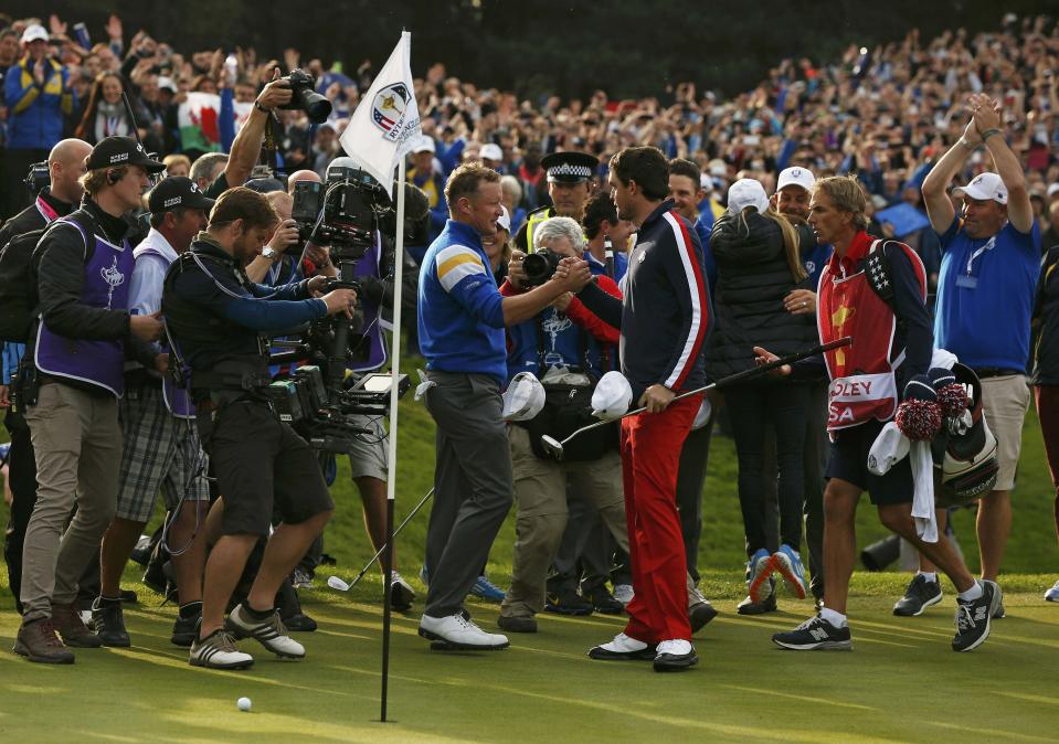 Team Europe golfer Jamie Donaldson (centre L) shakes hands with U.S. player Keegan Bradley after winning their match to retain the Ryder Cup for Europe on the 15th green during the 40th Ryder Cup at Gleneagles in Scotland September 28, 2014. REUTERS/Phil Noble (BRITAIN - Tags: SPORT GOLF)