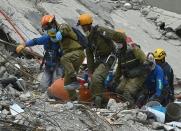 Rescuers remove the body of a man who survived the quake in Mexico City but died before they were able to reach him