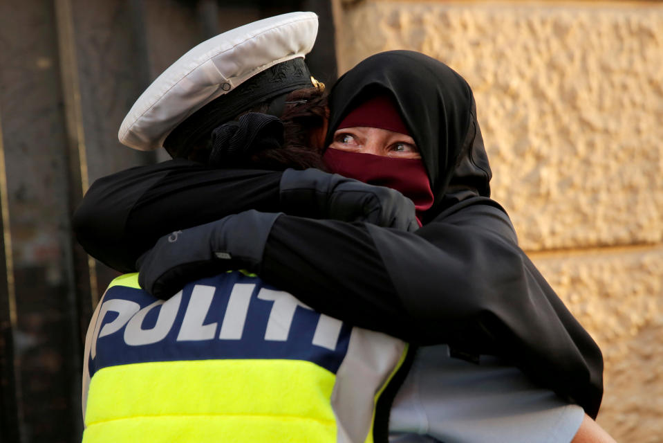 <p>Ayah, de 37 años, llora mientras que se abraza a un agente durante una manifestación contra la prohibición del niqab en Dinamarca. El autor de la imagen cuenta que vio a un policía hablando con varias mujeres que llevaban el velo. Cuando se acercó, no sabía si las iba a multar, pero se dio cuenta que estaba siendo muy amigable. Cuando Ayah se puso a llorar, se abrazaron.<br>Foto: REUTERS/Andrew Kelly </p>