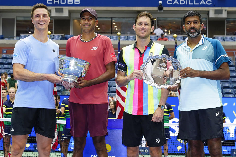 Joe Salisbury, of Great Britain, left, and Rajeev Ram, of the United States, pose for a photo with the championship trophy after defeating Rohan Bopanna, of India, far right, and Matthew Ebden, of Australia, during the men's doubles final of the U.S. Open tennis championships, Friday, Sept. 8, 2023, in New York. (AP Photo/Frank Franklin II)