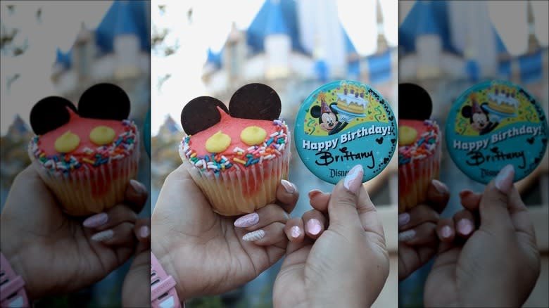 holding Mickey Mouse cupcake badge