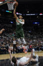 Milwaukee Bucks' Giannis Antetokounmpo (34) goes up to dunk as San Antonio Spurs' Jakob Poeltl, bottom, falls during the second half of an NBA basketball in San Antonio, Texas, Saturday, Oct. 23, 2021. (AP Photo/Chuck Burton)