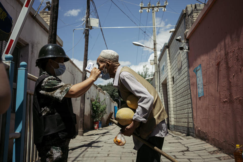 An old Uyghur man is tested at a temperature checkpoint on June 29, 2020 in Kuqa, Xinjiang. Source: David Liu/Getty