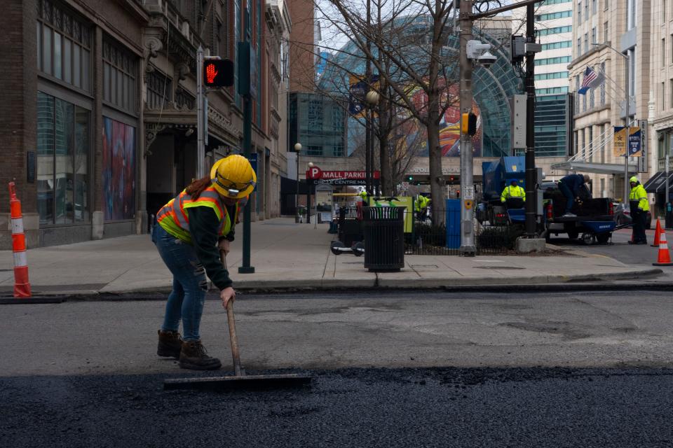 Construction workers repave the road as they prepare the city for the upcoming All-Star Game weekend Monday, Feb. 12, 2024, along South Meridian Street in Indianapolis.