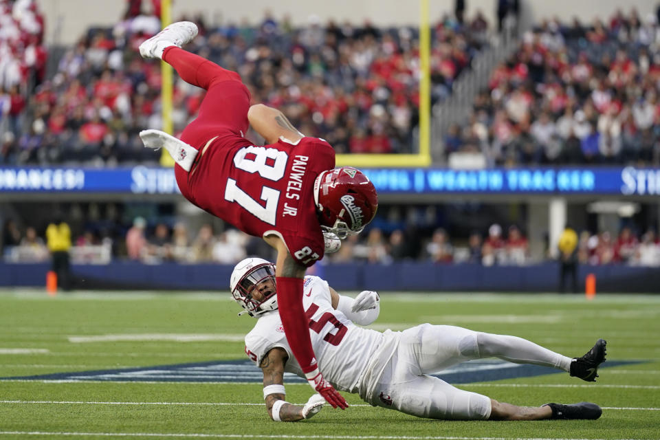 Fresno State tight end Raymond Pauwels (87) jumps over Washington State defensive back Derrick Langford Jr. (5) during the first half of the LA Bowl in Inglewood, Calif., Saturday, Dec. 17, 2022. (AP Photo/Ashley Landis)