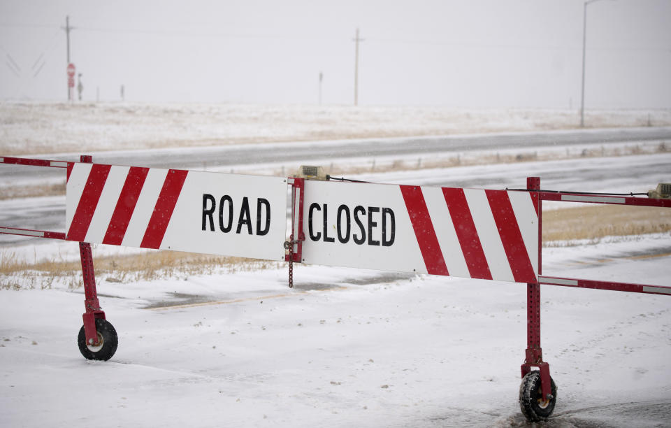 The gate is closed on an on ramp to the eastbound lanes of Interstate 70 at East Airpark Road Tuesday, Dec. 13, 2022, in Aurora, Colo. A massive winter storm has closed roads throughout northeast Colorado. (AP Photo/David Zalubowski)