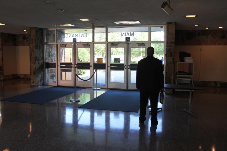 A security guard stands inside the lobby at Lakewood High School.