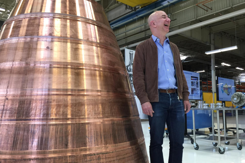 Amazon.com founder Jeff Bezos stands next to a copper exhaust nozzle to be used on a space ship engine during a media tour of Blue Origin, the space venture he founded, Tuesday, March 8, 2016, in Kent, Wash. The private space company opened its doors to the media for the first time on Tuesday to give a glimpse of how organizations like Blue Origin are creating the next generation of rockets for private and public use. (AP Photo/Donna Blankinship)